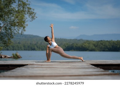 Beautiful attractive Asian woman practice fitness yoga pose on the pool above the Mountain peak in front of nature lake views, Feel so comfortable lifestyle and relax exercise in holiday morning - Powered by Shutterstock