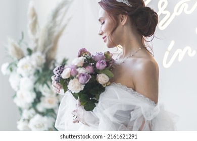 Beautiful attractive caucasian young woman in a white wedding dress with a bridal flower bouquet. Smiling - Powered by Shutterstock