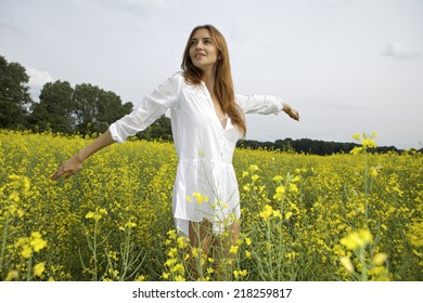 Beautiful Attractive And Sensuality Young Adult Brunette Woman In White Shirt Dress On A Yellow Flowers Field