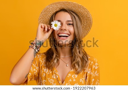 Photo of beautiful attractive stylish woman in yellow dress and straw hat holding daisy flower romantic mood posing on yellow background isolated in love summer fashion trend style, natural look