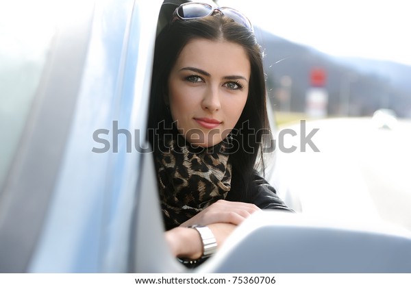 Beautiful attractive woman in car, looking through\
the window