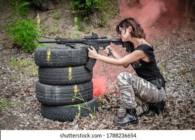 Beautiful and attractive woman soldier shooting with rifle machine gun from behind and around cover or barricade. Female  army military combat training on the shooting range