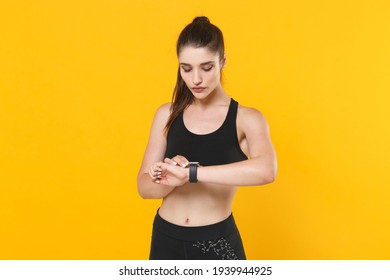 Beautiful Attractive Young Fitness Sporty Woman 20s Wearing Black Sportswear Posing Working Out Training Wearing Smart Watch On Hand Isolated On Bright Yellow Color Wall Background Studio Portrait