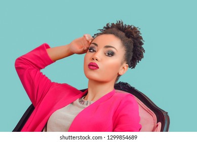 Beautiful Attractive Young Mixed Rase Woman With Make Up And In Pink Blazer Sitting In The Armchair