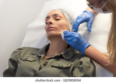 Beautiful, Attractive, Young Woman, Lying Relaxed In Dermatologist Ordination, Getting A Rejuvenating Facial Treatment With Hyaluronic Acid Filler. Cosmetics And Beauty  Corrections, Skin Care Concept