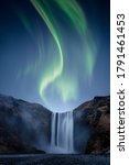 A beautiful Auora Borealis aka Northern Lights over Skogafoss waterfall in Iceland