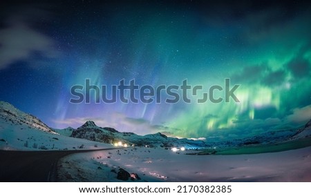 Beautiful Aurora borealis, Northern lights glowing over snow mountain and coastline in the night sky at Lofoten Islands, Norway