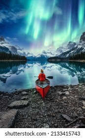 Beautiful aurora borealis over spirit island with female traveler on canoe at Jasper national park, AB, Canada