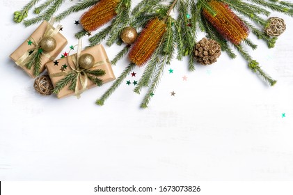 Beautiful Australian inspired Christmas composition. Native Banksia's with elegantly wrapped gifts, gold ribbon, decoration, pine cones and glitter one a white wooden background. - Powered by Shutterstock