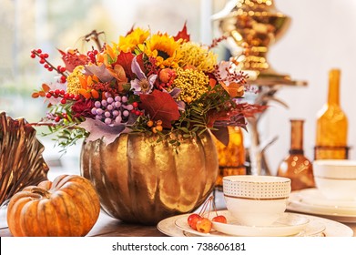 beautiful autumn composition in a pumpkin vase on a table
