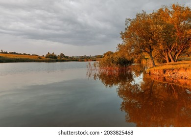 Beautiful autumn lanscape with trees reflection in water. Panorama of autumn evening lake. Tranquil evening view.