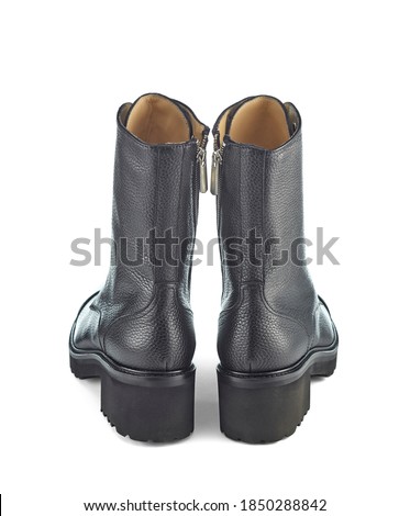 Beautiful autumn leather boots with a high top with laces and a massive sole with a low heel, isolated on a white background with a shadow. Rear view.