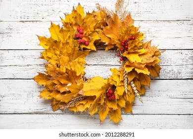 Beautiful autumn wreath on white wooden background