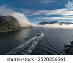 beautiful awesome amazing nice quiet nature with rocks sea fjord in norway Scandinavia and moving boat clouds laying on the water 