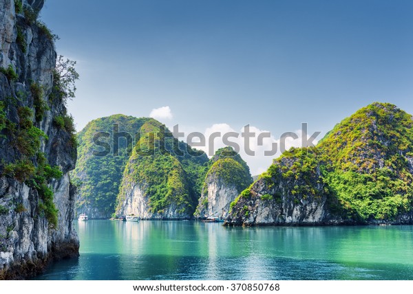 Beautiful azure water of lagoon in the Halong\
Bay (Descending Dragon Bay) at the Gulf of Tonkin of the South\
China Sea, Vietnam. Scenic landscape formed by karst towers-isles\
on blue sky\
background.