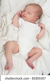 Beautiful Baby Boy Sleeping In A White Onesie