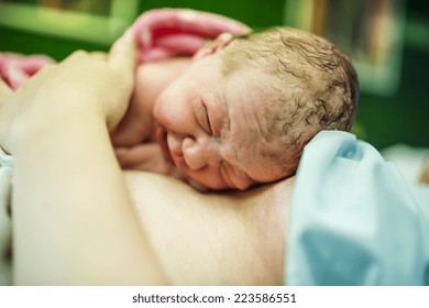 Beautiful Baby Girl Few Minutes After The Birth Lying On Her Mother, Skin To Skin Contact