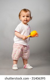 Beautiful Baby Girl With Orange Maraca.