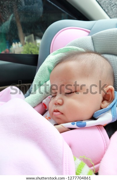 beautiful baby sleeping in car\
seat