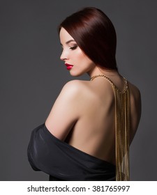 beautiful back of young woman in a black sexy dress.beauty brunette Girl with a necklace on her back.Elegant fashion glamor photo