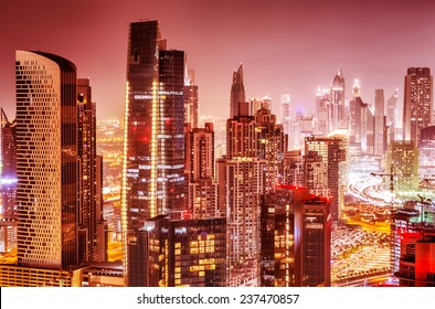 Beautiful background of Dubai at night, gorgeous cityscape over pink sky, many glowing lights of tall skyscrapers, luxury modern expensive architecture design