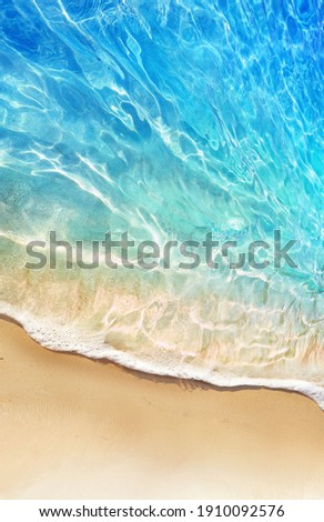 Beautiful background image tropical beach stretch of light sand, white breakers foam and amazingly clear water. Turquoise, blue, greenish shades of water and play of sunlight.