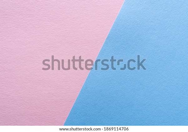 Beautiful background of two parts\
of colored paper pastel blue and pink. Sheets of blank light blue\
and pink paper with fine texture devided  by a sloping\
border.
