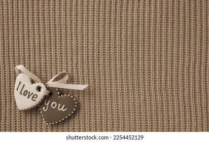 Beautiful background for Valentine's day. Hearts with the inscription I love you on a knitted background. Old Style