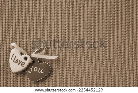 Beautiful background for Valentine's day. Hearts with the inscription I love you on a knitted background. Old Style