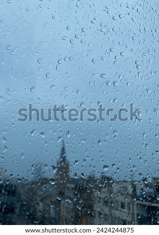 Beautiful background, water, raindrops on the window glass  and city view, church 
