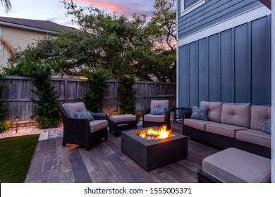Beautiful backyard firepit at dusk with comfortable chairs - Shutterstock ID 1555005371