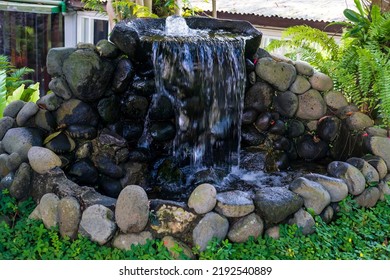 Beautiful Backyard Garden Pond With Natural River Stones And Clear Waterfall.