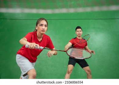 Beautiful badminton player in a stance with her male partner