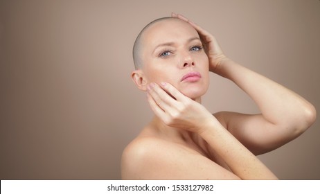 A Beautiful Bald Woman Caresses Her Head And Neck. Copy Space