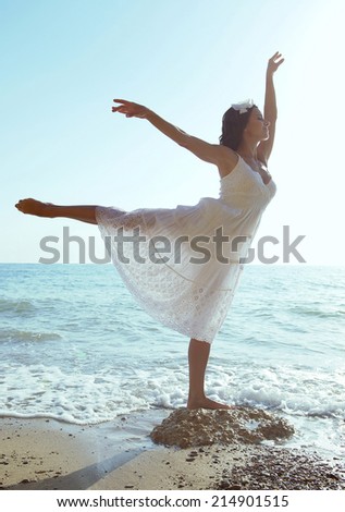 Beautiful ballet dancer woman posing on a beach. Summertime 