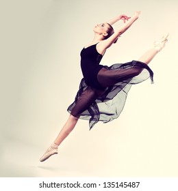 Beautiful ballet-dancer, modern style dancer posing on studio background