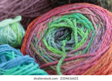 Beautiful balls of handspun yarn wool of a colourful skein of organic natural handspun and handdyed merino sheep wool, silk, linnen mix yarn fleece, spun on a traditional spinning wheel.	 - Powered by Shutterstock