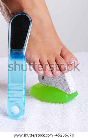 Beautiful barefoot female feet with a set of the pedicure tools