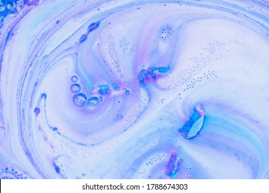 Beautiful bath bomb dissolves in blue and pink colors in the water. Abstract texture background