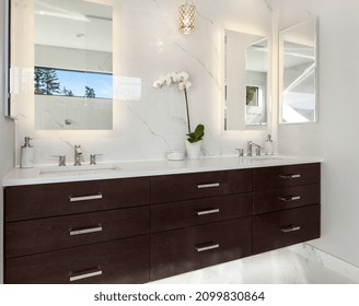 Beautiful Bathroom Vanity In New Luxury Home. Double Vanity With Undermount Sinks, Sconce Lights, Floating Cabinets, Mirrors, And Elegant Backsplash.