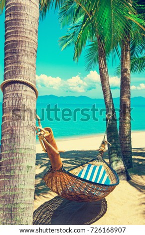 Beautiful beach. Hammock between two palm trees on the beach. Holiday and vacation concept. Tropical beach. Beautiful tropical island.