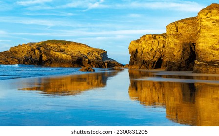 Beautiful beach and rock formation with reflection in atlantic ocean at sunset- galicia, Spain - Powered by Shutterstock