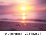 Beautiful beach with sunrise background. Focus on sea shell.