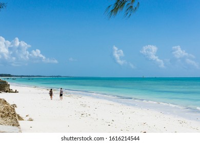 Beautiful Beach And Tropical Sea With Two Idefinite Turists In Jambiani, Zanzibar, Tanzania Africa