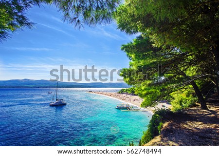 Beautiful beach Zlatni Rat or Golden Cape on island Brac in Croatia with yacht