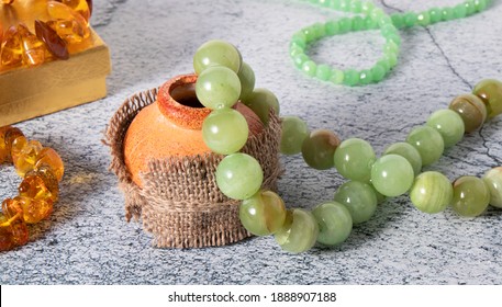 Beautiful Beads Made From Natural Green-yellow Onyx, Agate  (layered Chalcedony) Stone With Jade Beads And Baltic Amber Jewelry On A Gray Surface. Retro Composition. 