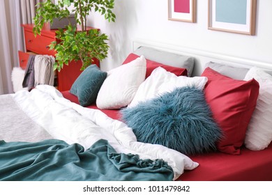 Schönes Bett mit Kissen im Zimmer