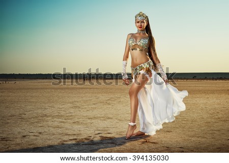 Beautiful belly dancer against landscape