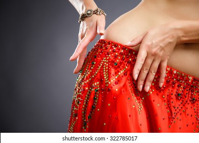 Beautiful belly dancer young woman in gorgeous red and green costume dress. Part of body
