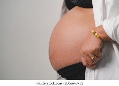 Beautiful Belly Or Pregnant Sideview Woman Wear A Wedding Ring And Hugging Her Tummy Isolated On White Background Studio Shot.